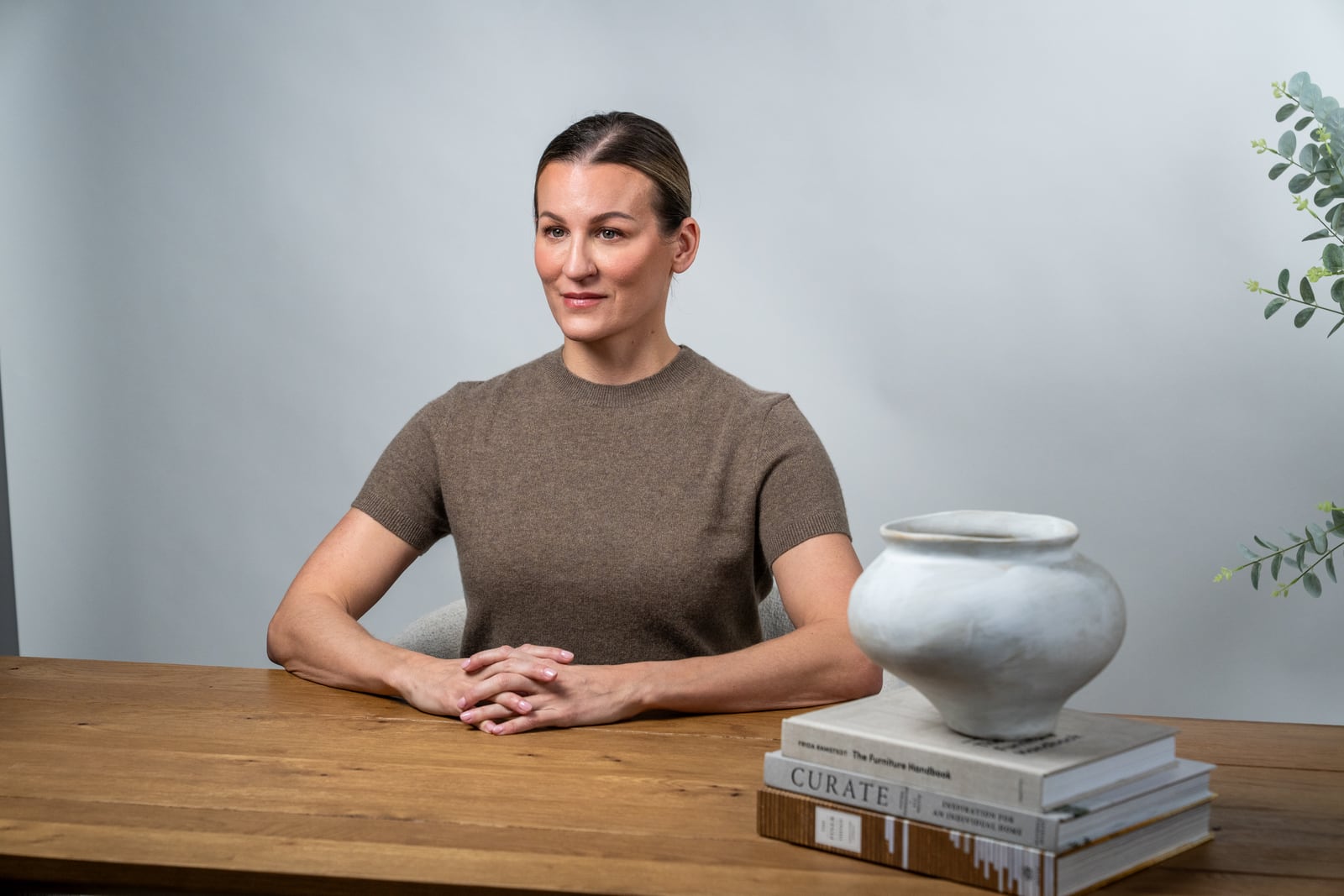 Dr. Marie Claire Bourque seated at a desk with her hands folded in a calm, plainly furnished room