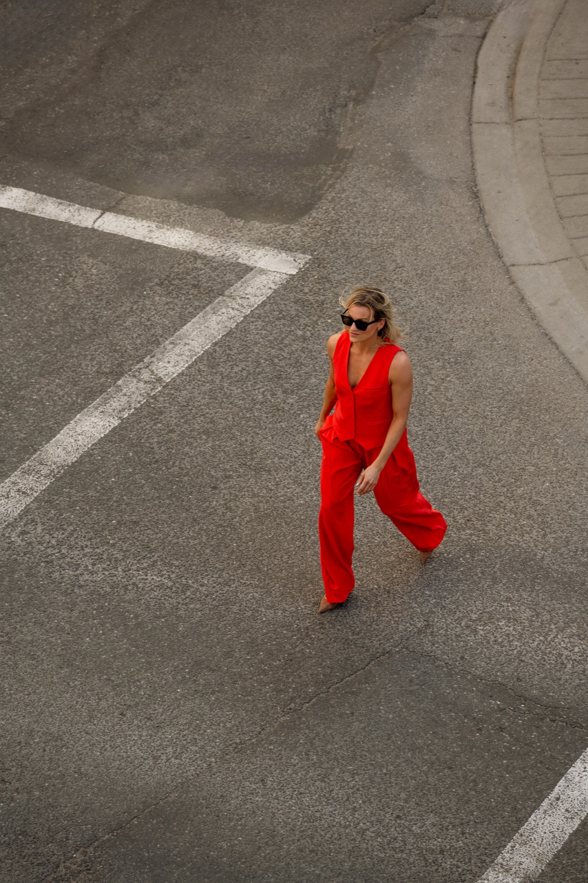 Dr. Marie Claire Bourque crossing a city intersection in a red suit