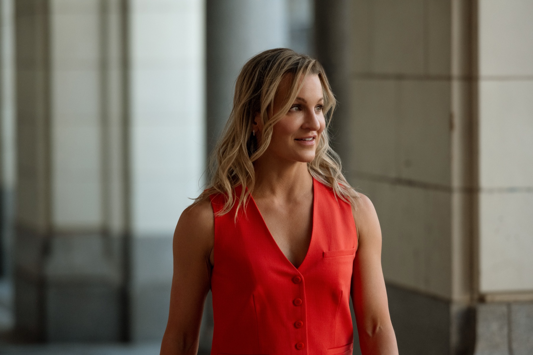 Dr. Marie Claire Bourque in a red vest in a modern interior