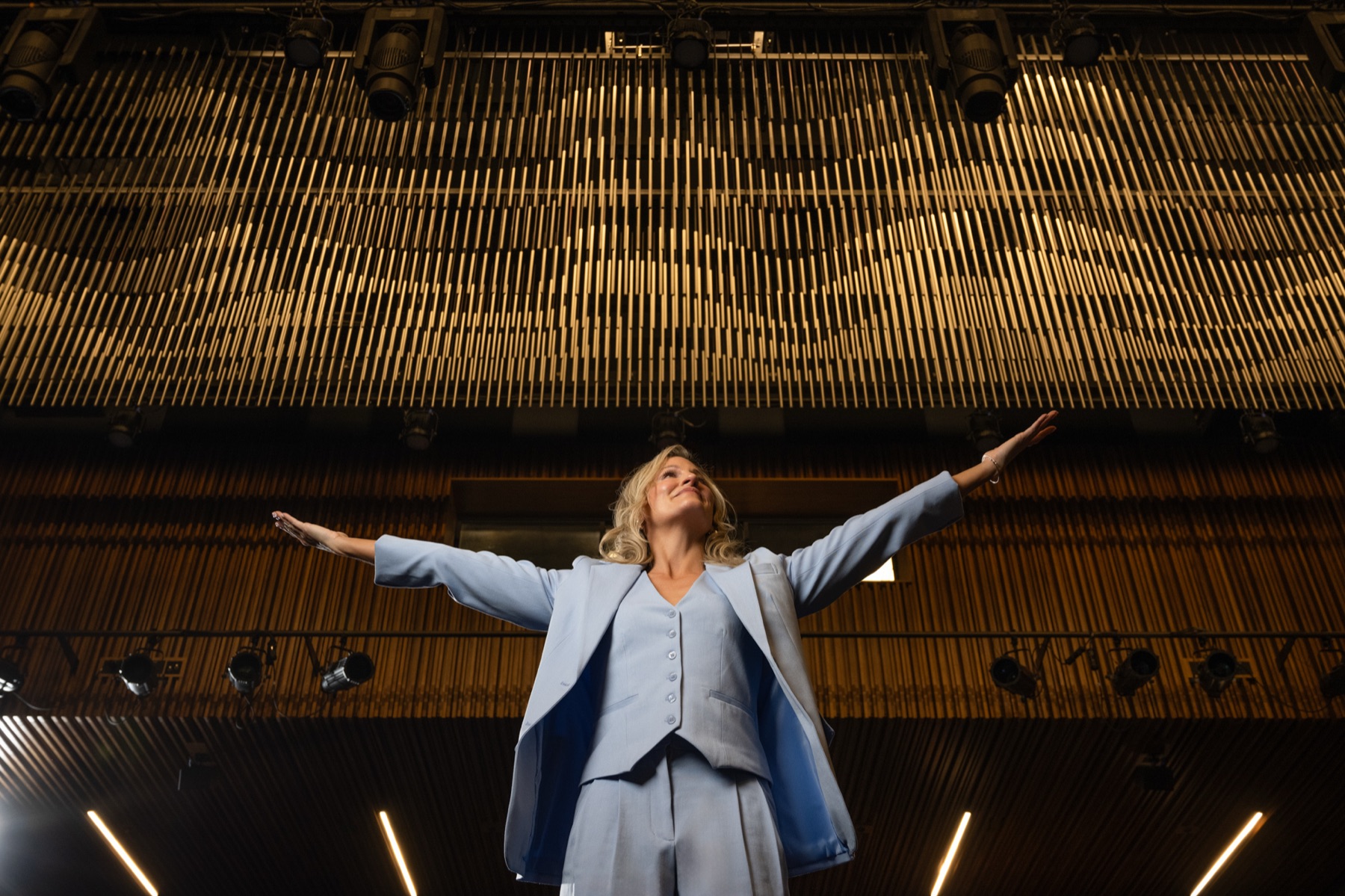Dr. Marie Claire Bourque standing onstage with her arms open